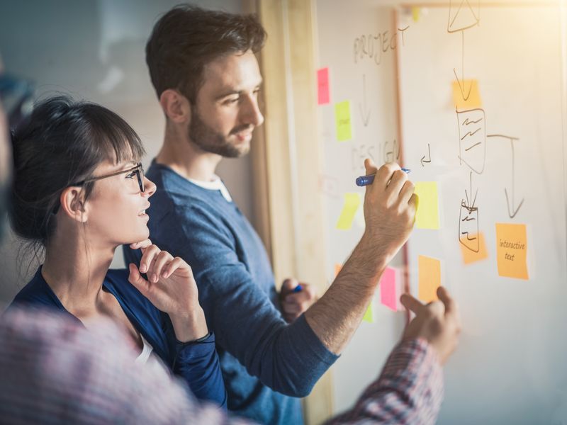 Teilnehmerinnen und Teilnehmer der Werbe Akademie lernen und arbeiten gemeinsam an einer Präsentation