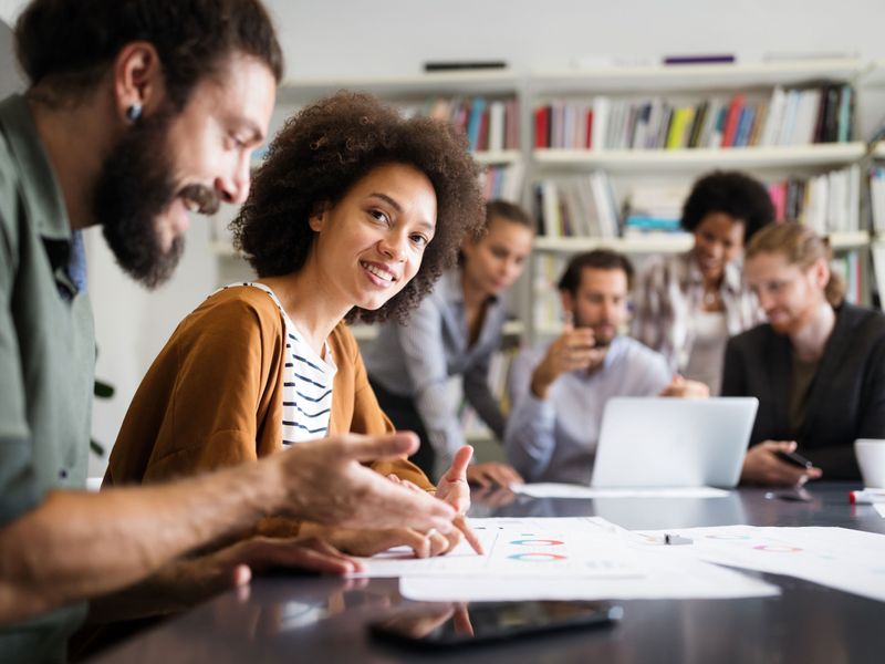 Teilnehmerinnen und Teilnehmer der Werbe Akademie lernen und arbeiten gemeinsam an einer Präsentation